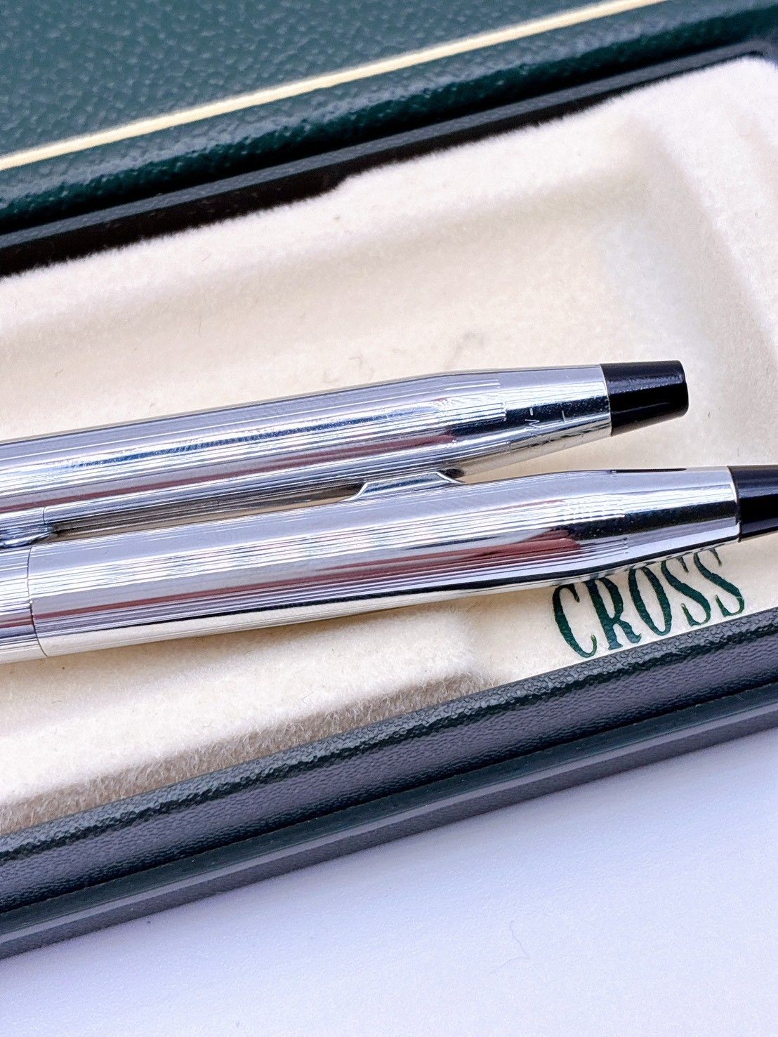 Two CROSS silver mechanical pencils with model MN228 displayed next to a silver box