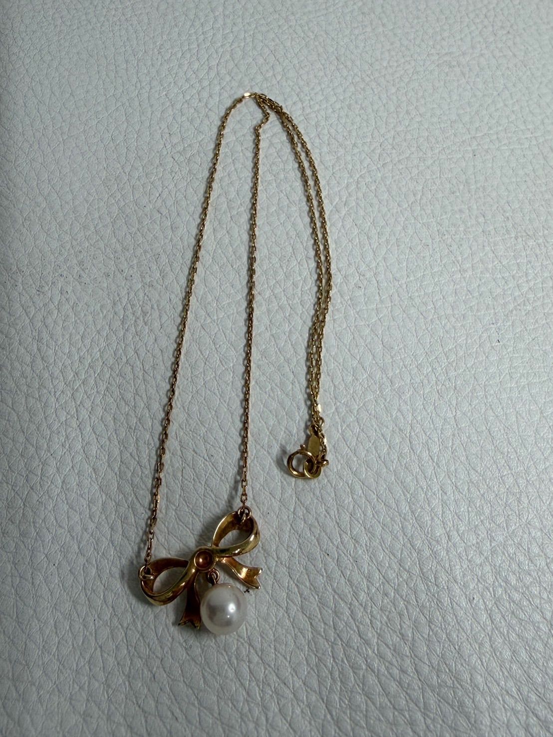 MIKIMOTO K18 yellow gold ribbon necklace featuring a single pearl decoration