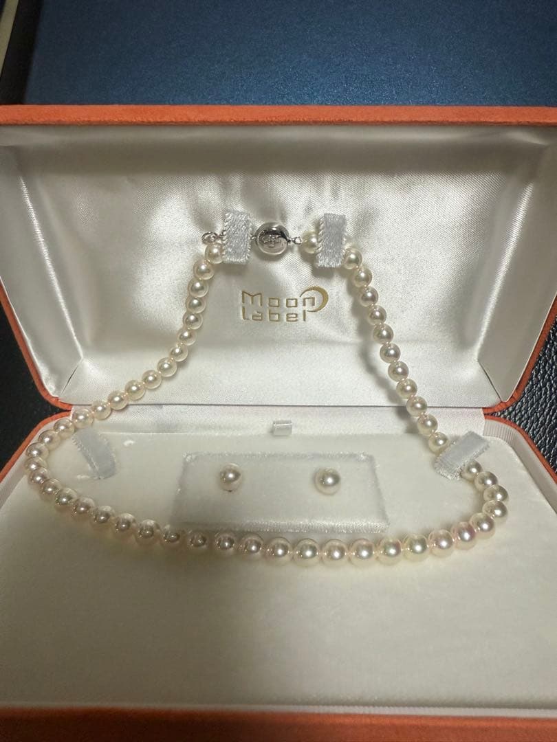 Close-up of Akoya pearl necklace made with SV925 silver, displayed with certification and box