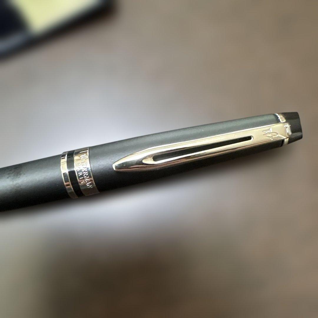 Used Waterman black ballpoint pen with a leather case showing a dent