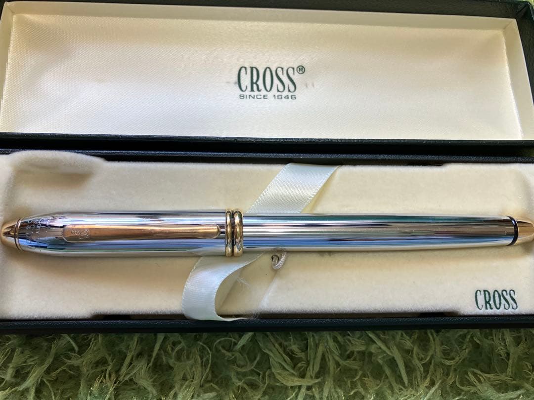 Silver CROSS ballpoint pen with two-tone metal design beside its dedicated protective case