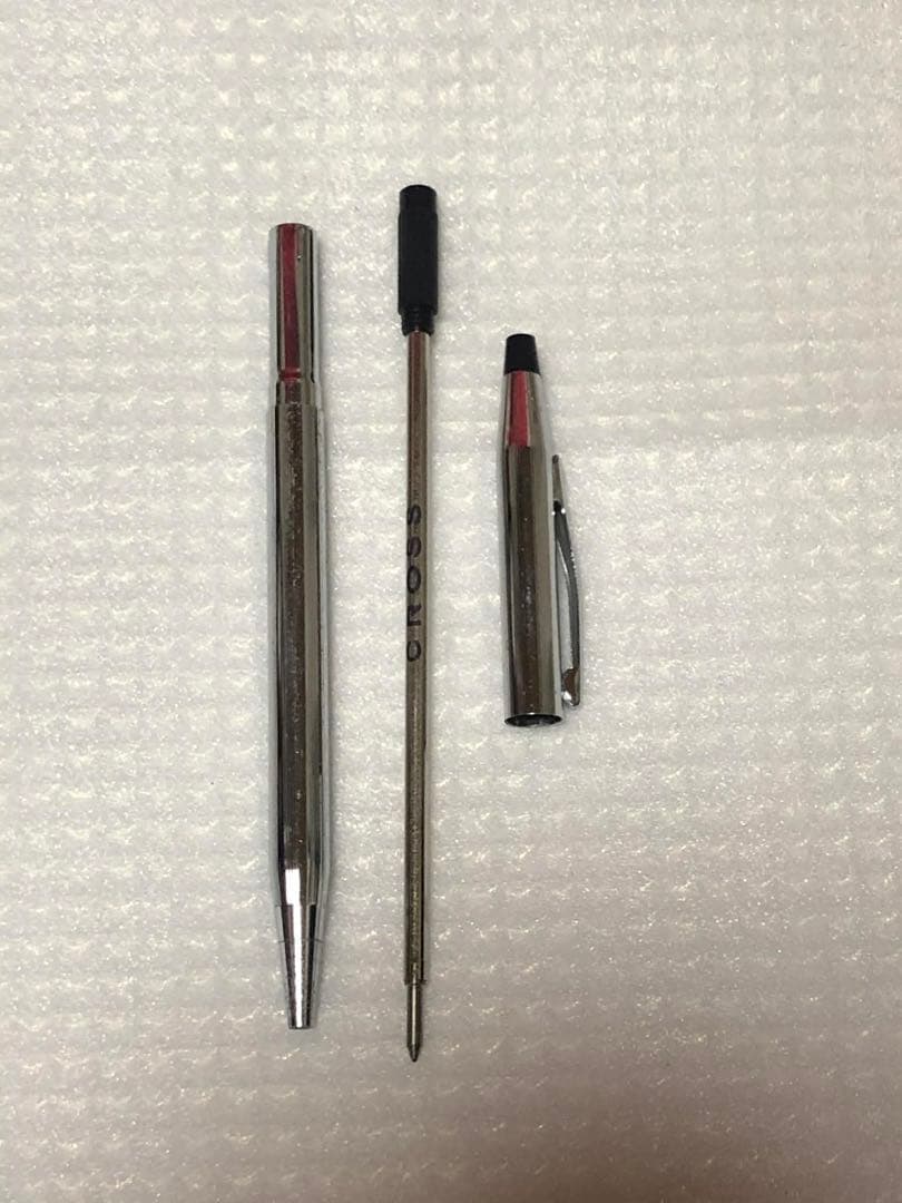 Kuro Cross ballpoint pen with sleek black barrel and silver accents on white background