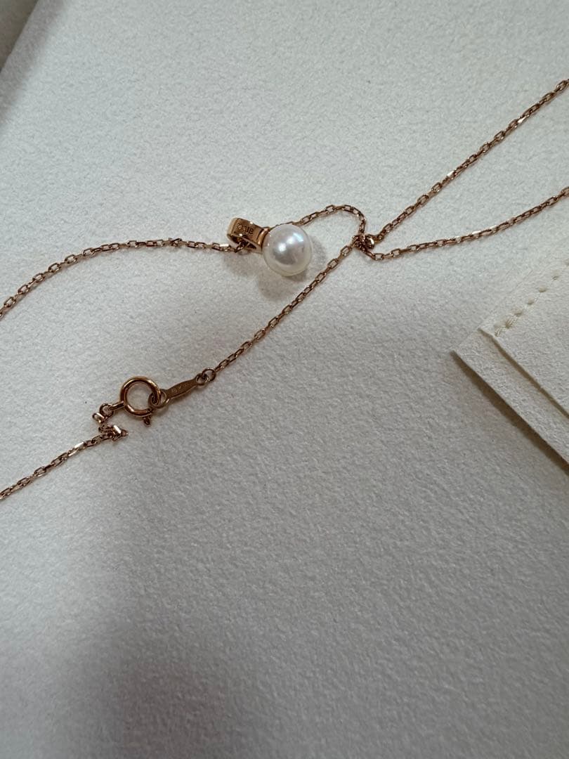 Mikimoto pink gold chain necklace with a single pearl pendant on white background