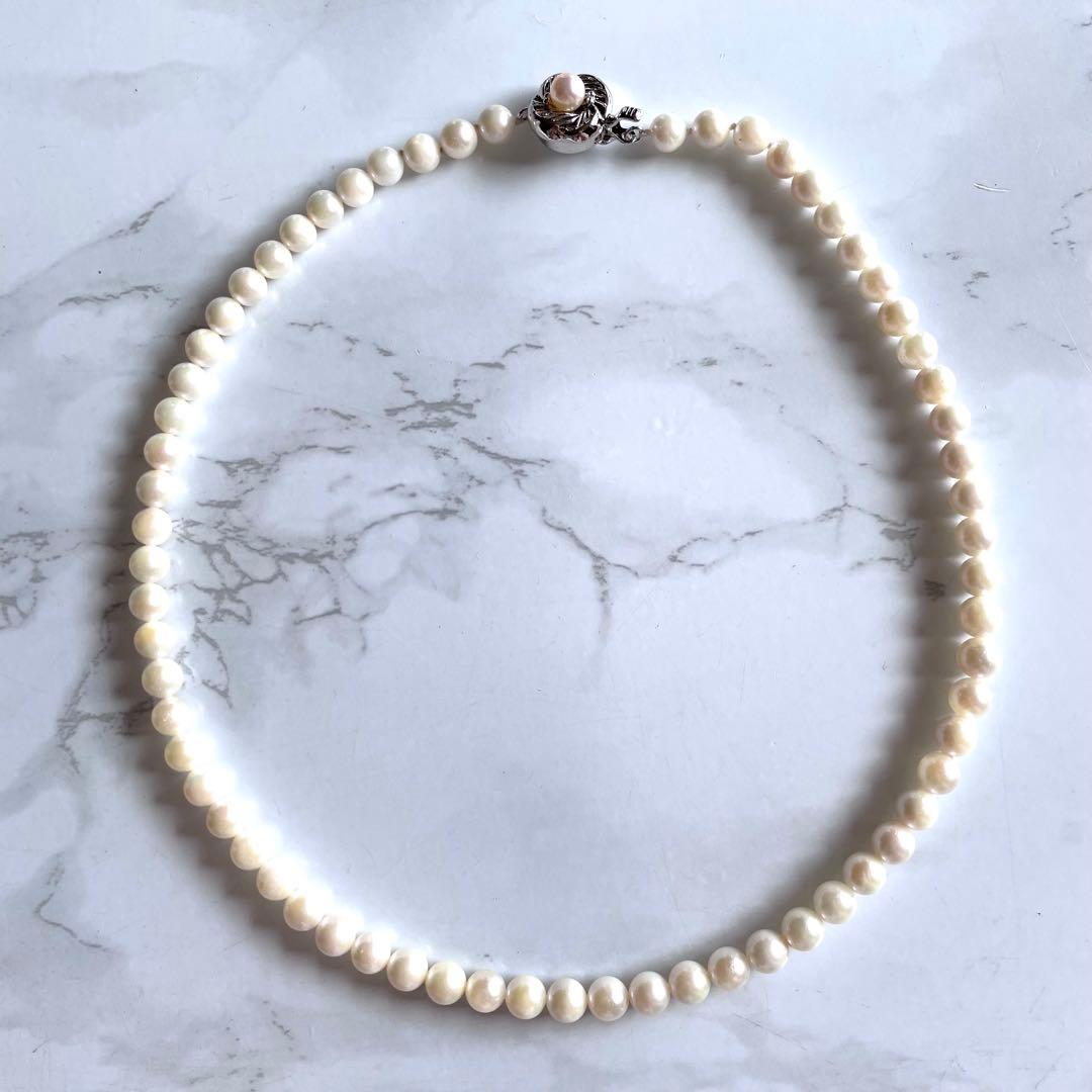 Akoya pearl necklace with white 6.0 to 6.5mm pearls and silver clasp on a white background