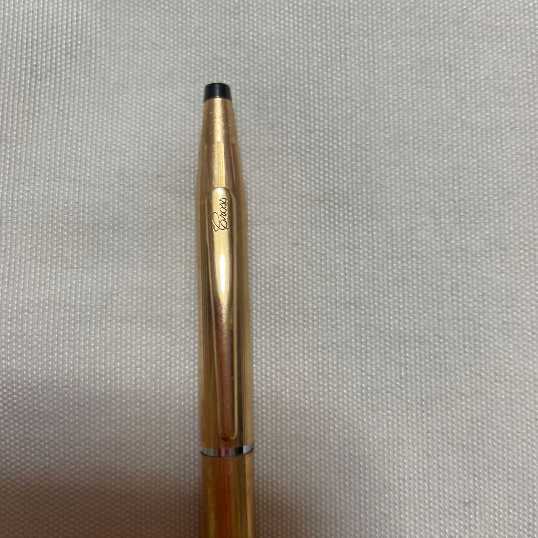 Used CROSS ballpoint pen with black ink tip and sleek silver body shown from side view