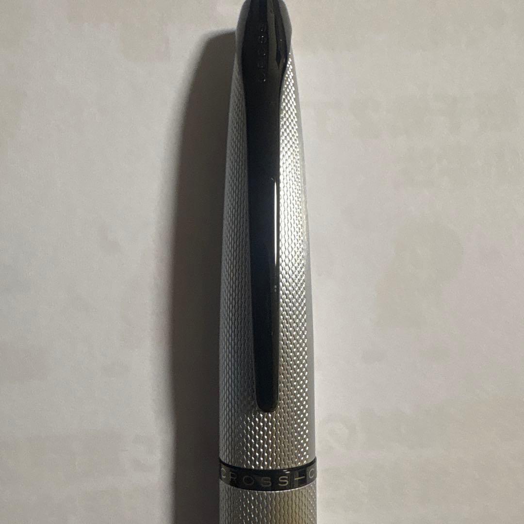 Close-up of Cross ballpoint pen with sleek black barrel and silver clip on white background