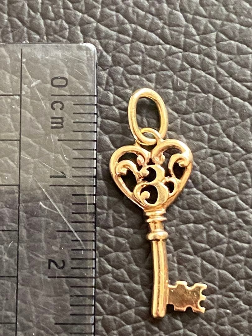 Agate K10 gold pendant top featuring a key motif in gold color
