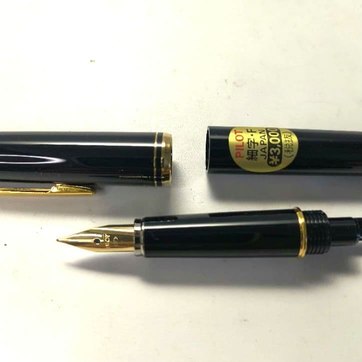 Unused PILOT fountain pen with black barrel and silver clip shown on a white background