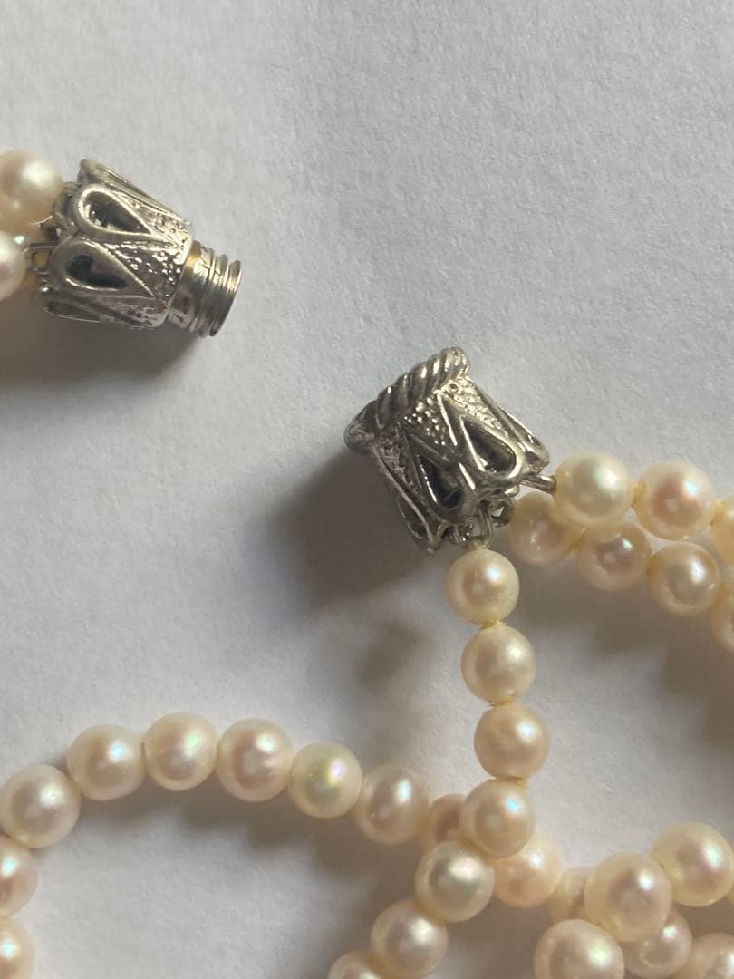 Three-strand pearl necklace with small 4mm Akoya pearls displayed on a white background