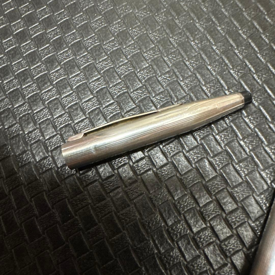 Vintage CROSS Kuro sterling silver early model ballpoint pen with black ink, showing used condition and dents