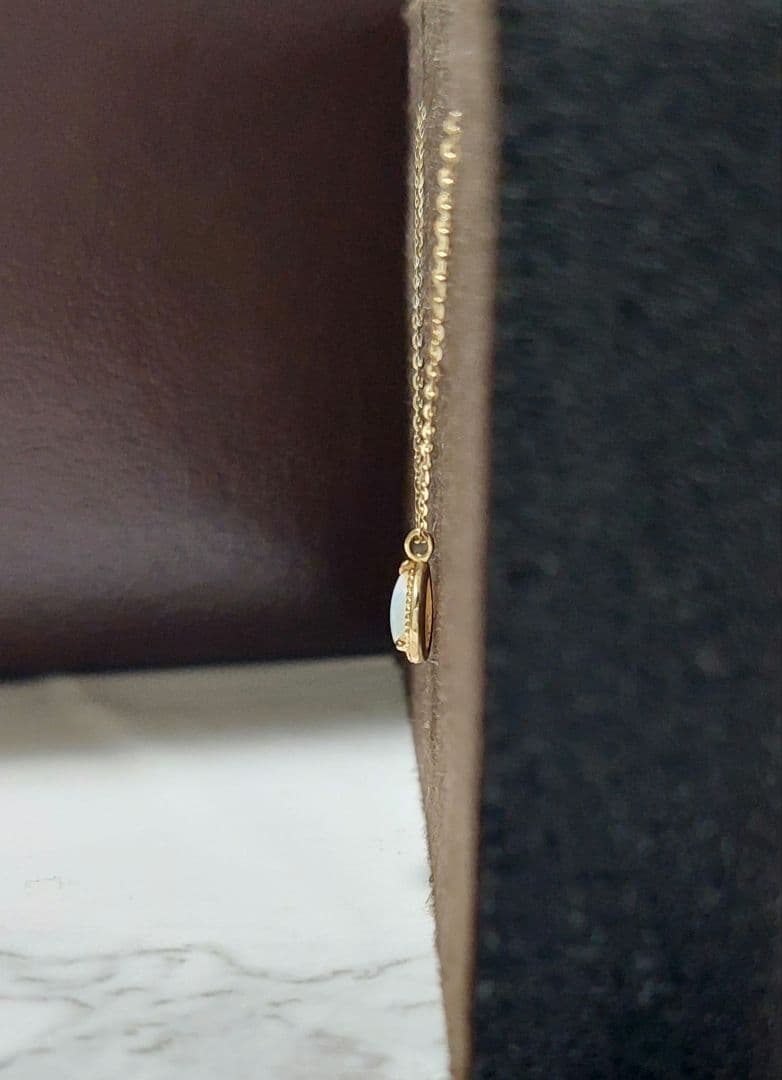 Current Model Agate K10 necklace with opal pendant measuring 0.6 by 0.4 cm on 40 cm gold chain