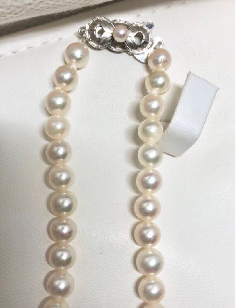 Akoya pearl necklace with round white pearls 5.5-6.0mm and silver clasp on a white background