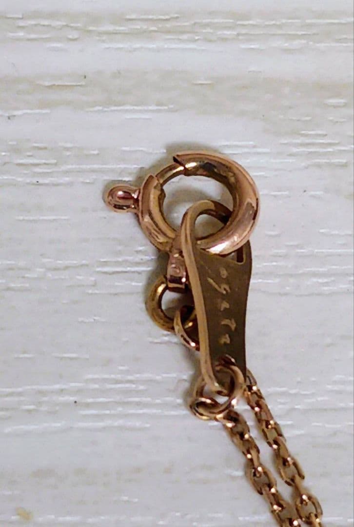 Close-up of pink gold necklace featuring an open heart-shaped agate stone with small diamonds