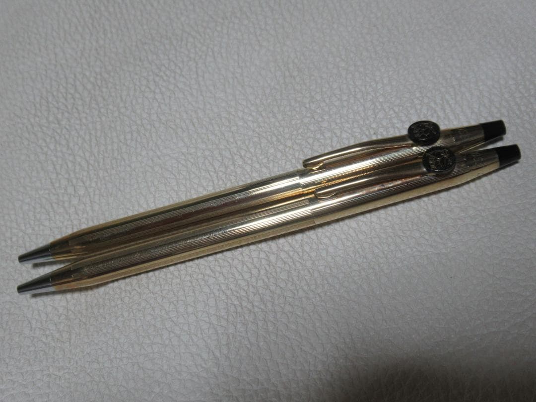 Two Merrill Lynch Cross Century 10K gold filled ballpoint pens with twist mechanism and engraved emblem