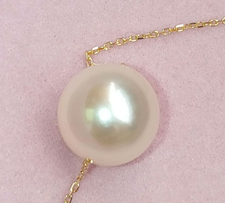 Akoya pearl pendant with 18 karat gold setting and 38cm chain on white background