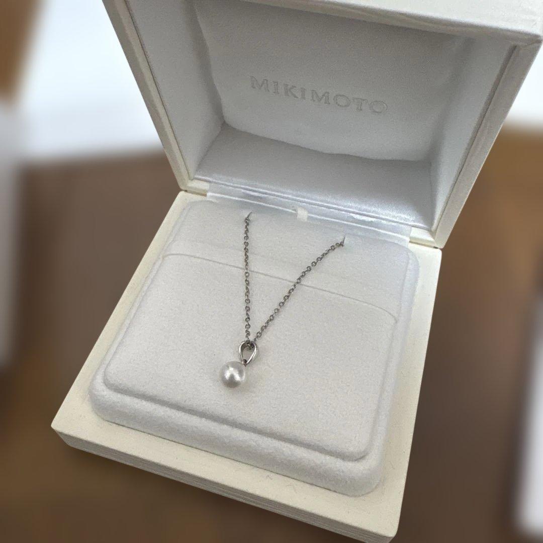 Mikimoto pearl pendant necklace with a single pearl on a delicate chain, displayed on a white background