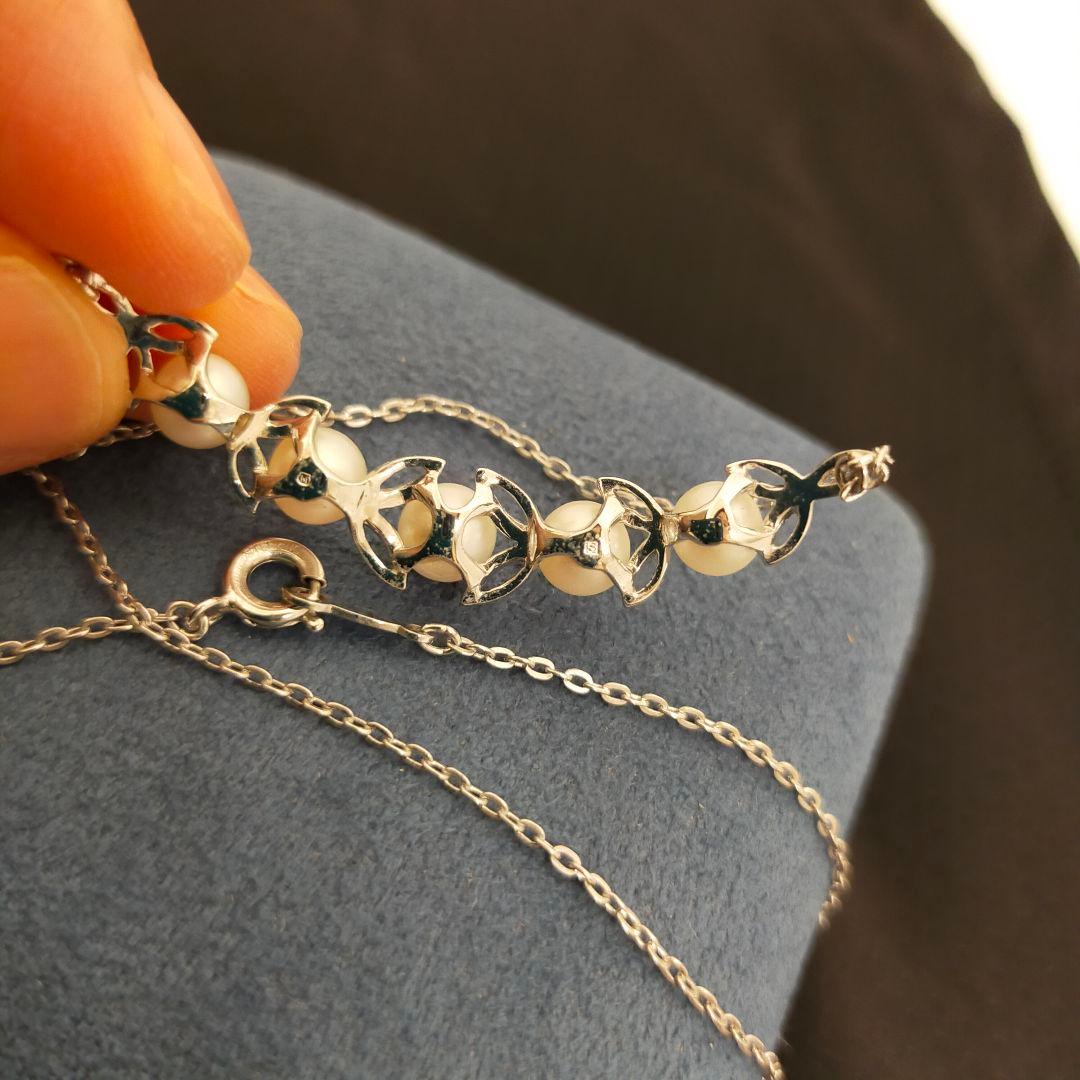 MIKIMOTO 5-row pearl necklace with leaf motif silver design featuring five pearls displayed on white background