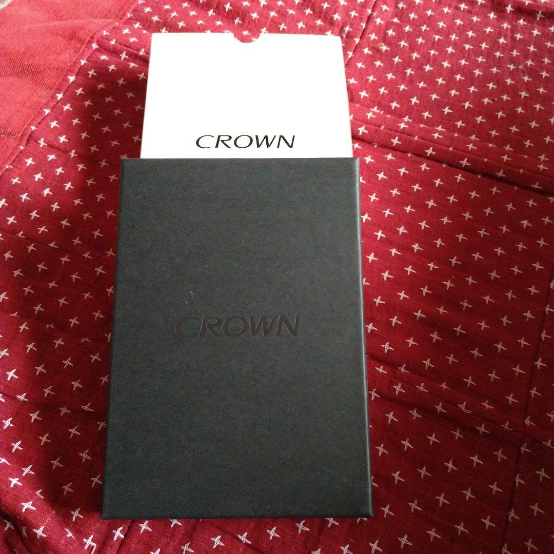 Crown pin badge set with black ballpoint pen and included gift box on white background