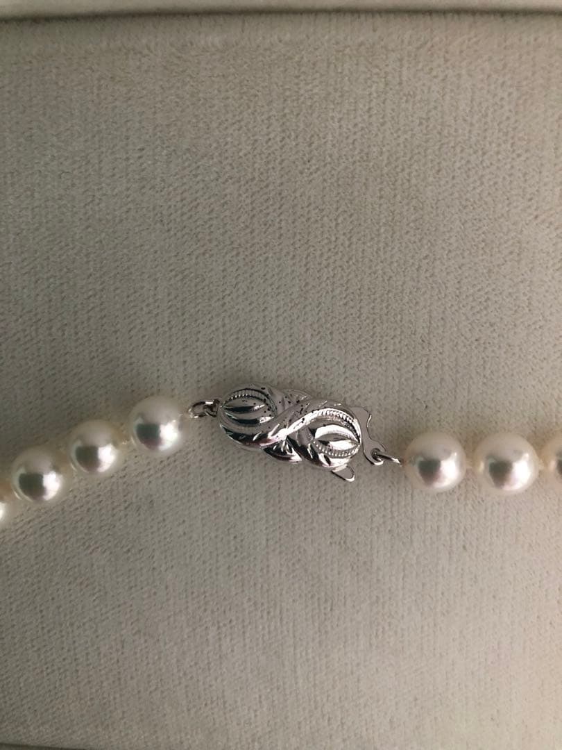 Elegant pearl necklace featuring 57 pearls and a silver clasp on a white background