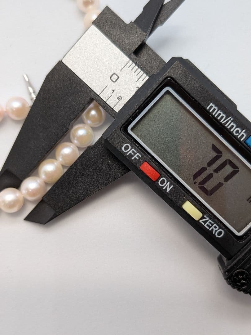 Close-up of an Akoya pearl necklace with 6.5-7mm pearls and a sterling silver clasp on a white background