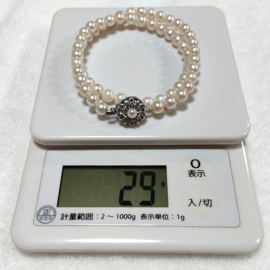 Akoya pearl necklace with 4-7mm white pearls and silver stamp clasp on a white background