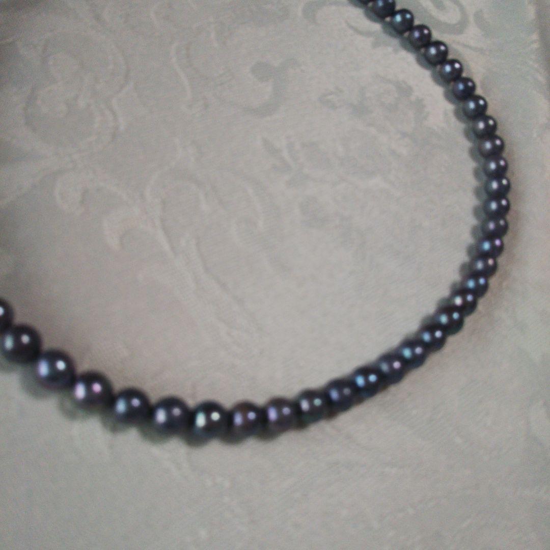 Akoya pearl necklace and matching earrings with silver clasp and findings on white background