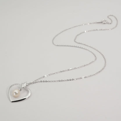 Mikimoto heart-shaped pearl necklace with silver chain displayed against white background