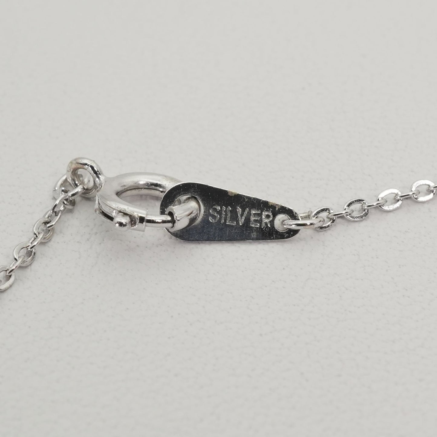 Mikimoto heart-shaped pearl necklace with silver chain displayed against white background