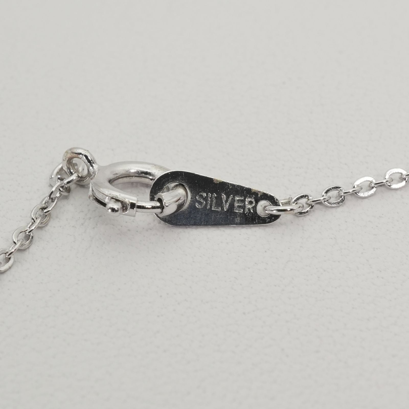 Mikimoto heart-shaped pearl necklace with silver chain displayed against white background