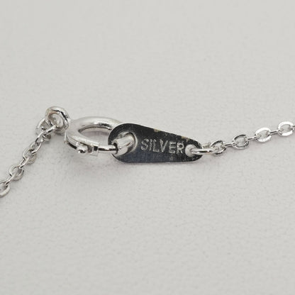Mikimoto heart-shaped pearl necklace with silver chain displayed against white background