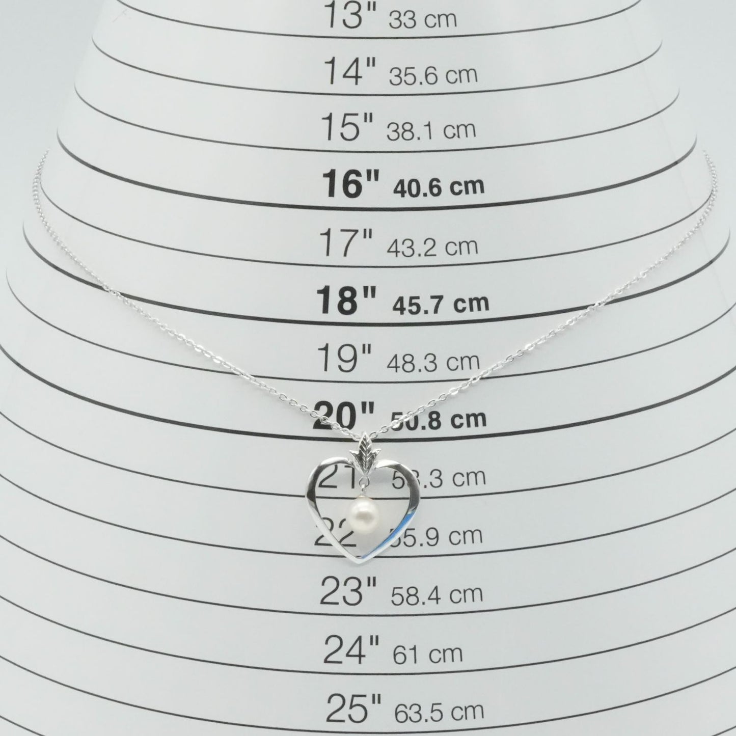 Mikimoto heart-shaped pearl necklace with silver chain displayed against white background