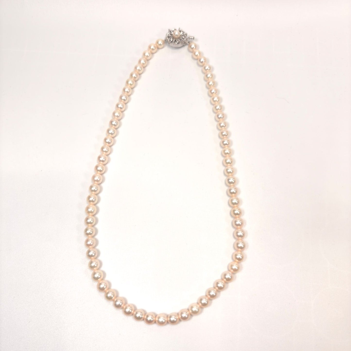 Akoya pearl necklace with 6mm real pearls and silver clasp displayed on a white background