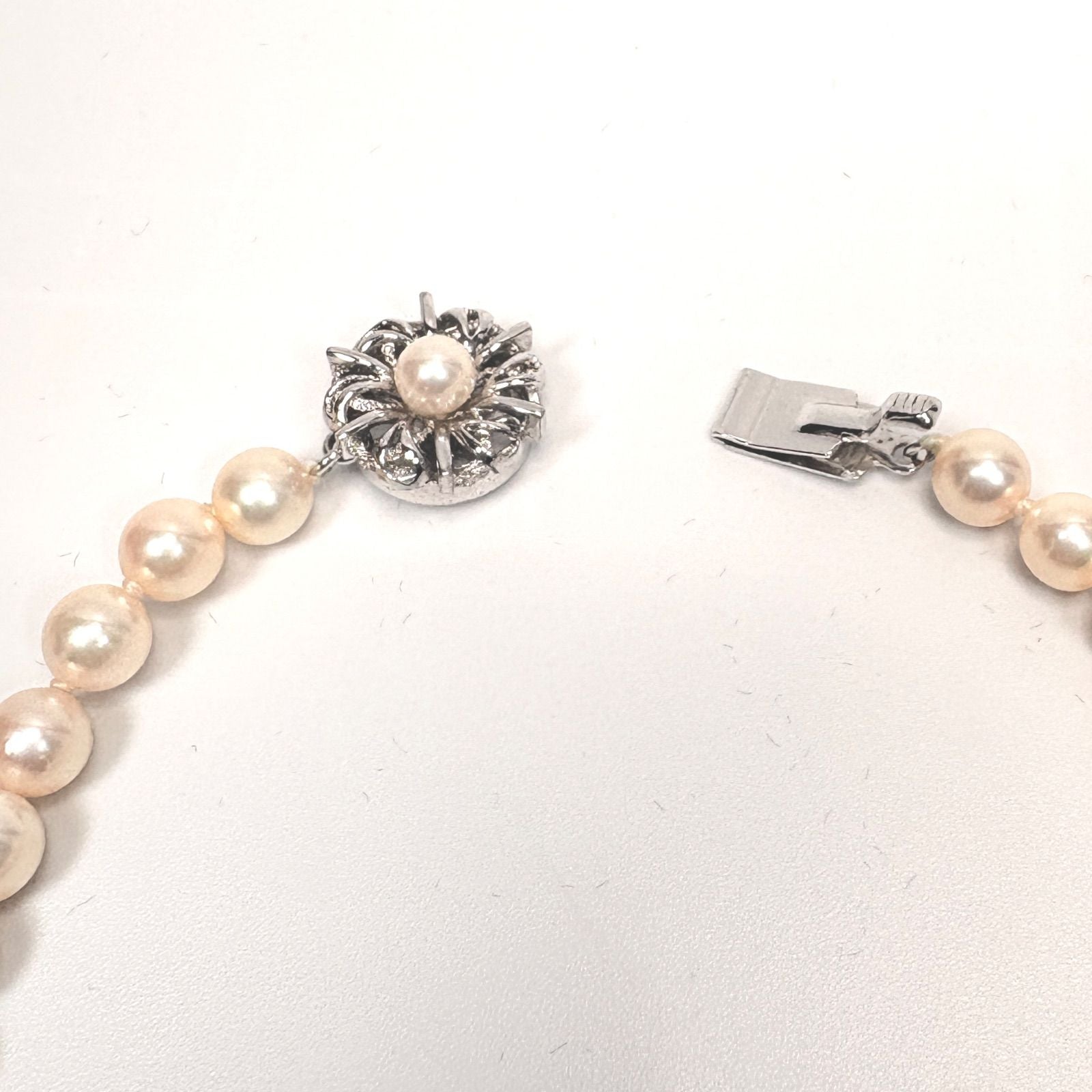 Akoya pearl necklace with 6mm real pearls and silver clasp displayed on a white background