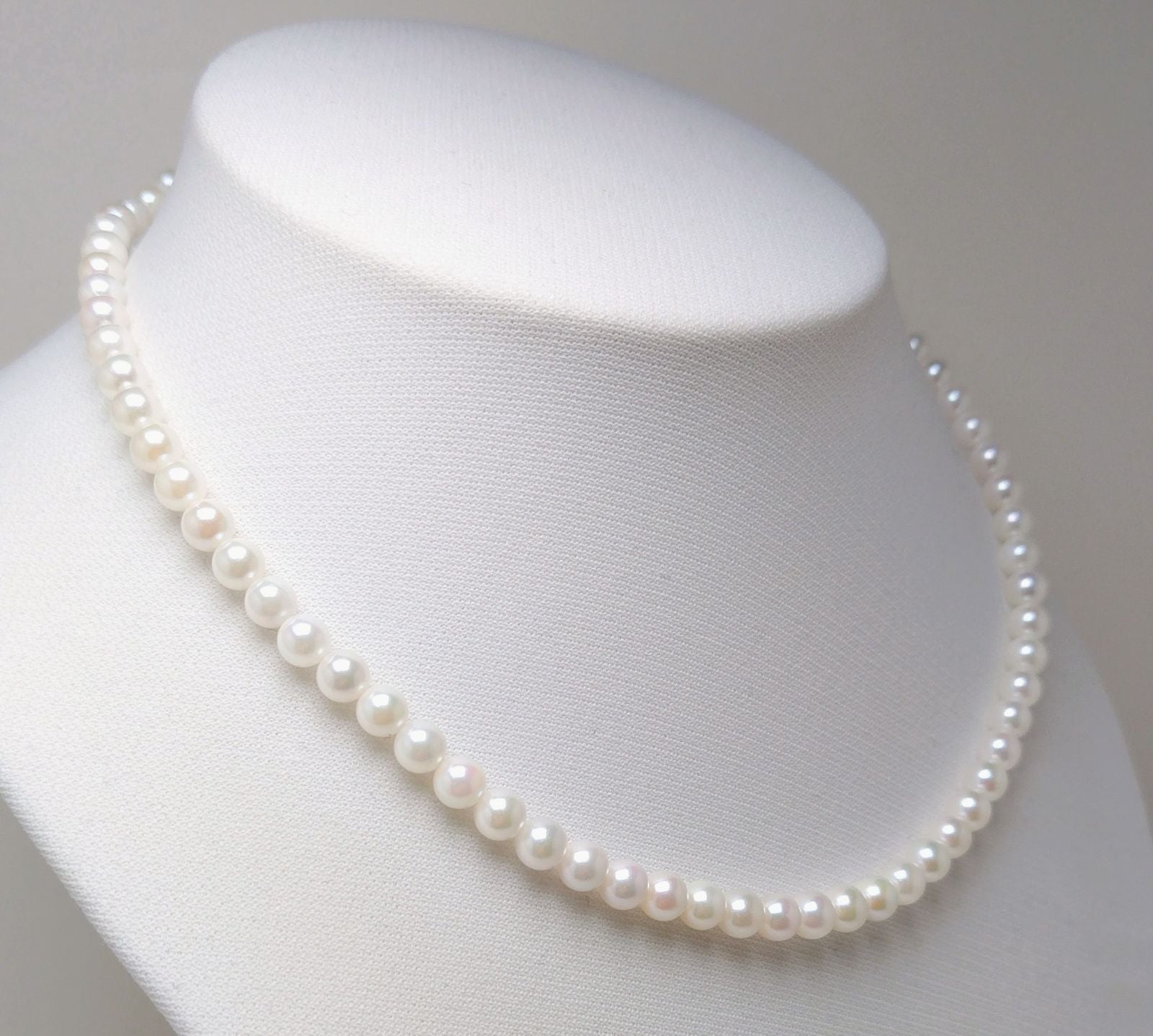 Akoya pearl necklace featuring round 5.5-6.0mm white, green, and pink pearls with good luster