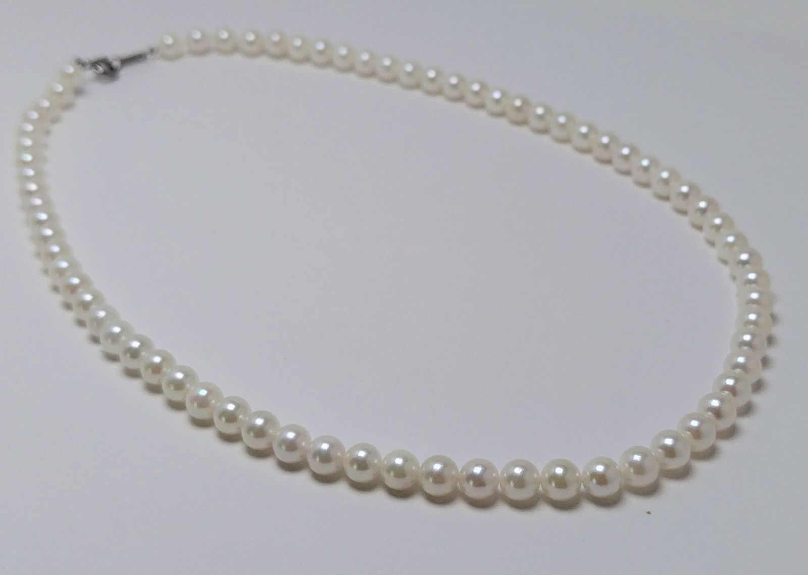 Akoya pearl necklace featuring round 5.5-6.0mm white, green, and pink pearls with good luster