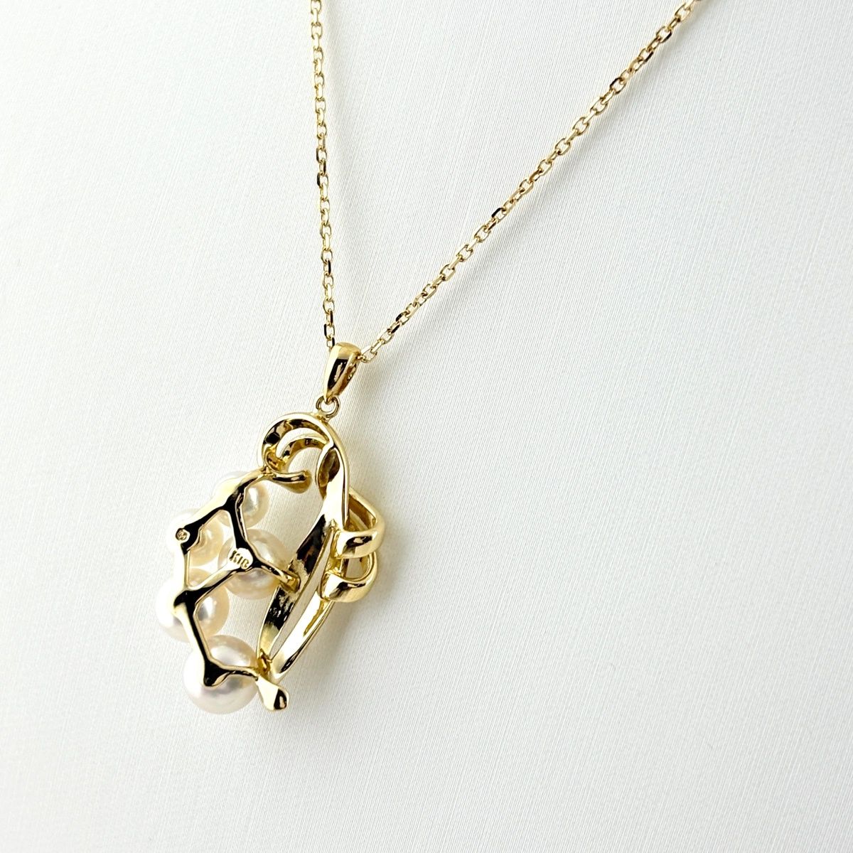 Mikimoto pearl necklace with yellow gold pendant and 39.5 cm chain on white background