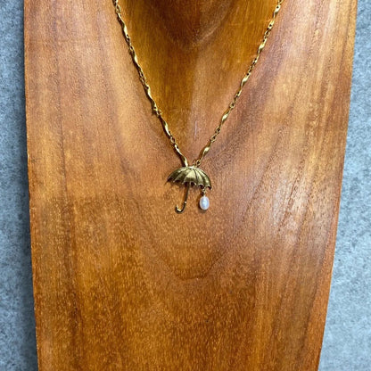 Tasaki necklace top with umbrella motif in K18 yellow gold featuring a pearl, shown in used condition with small scratches