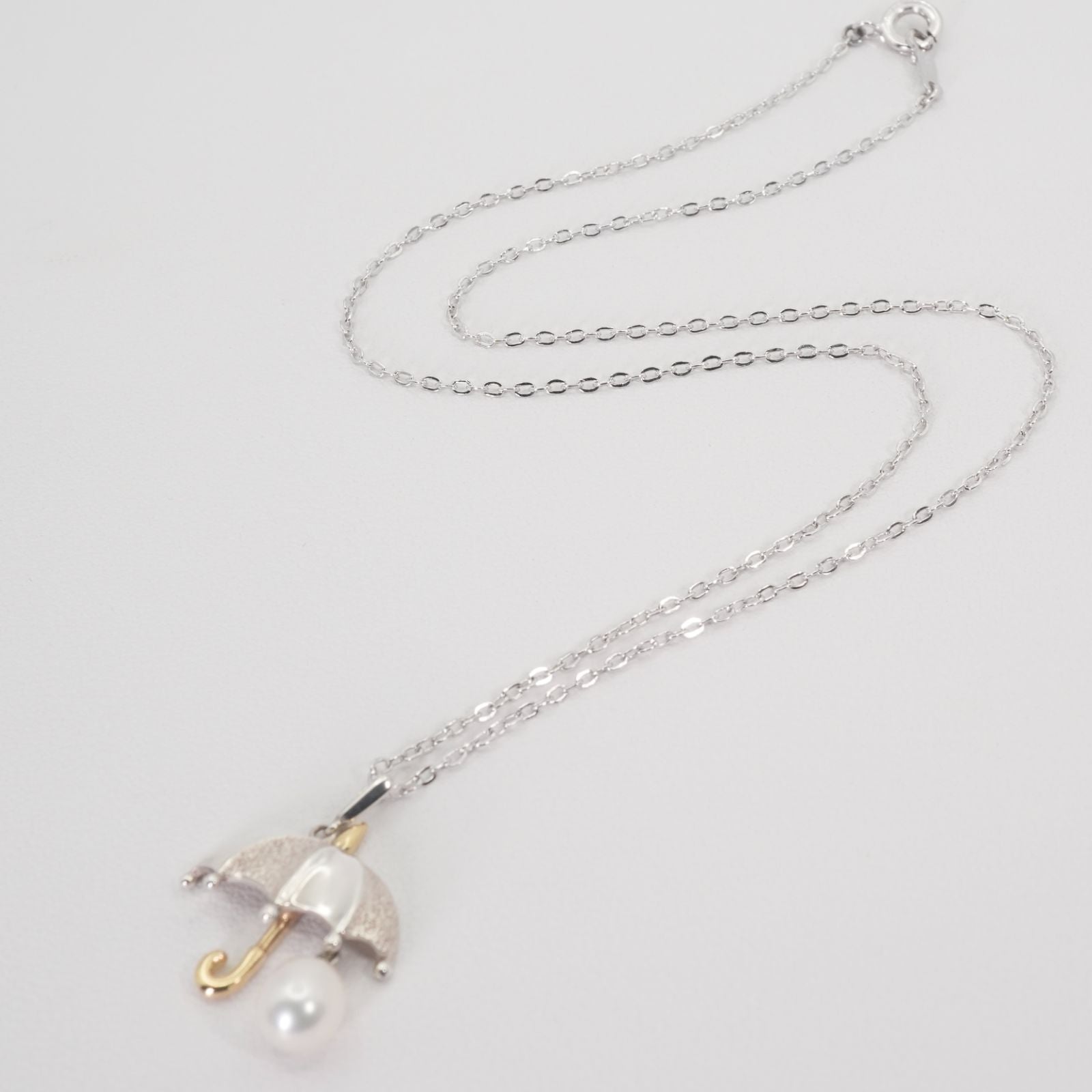 Mikimoto Umbrella Necklace made of silver, K18 gold, and pearl shown on a white background