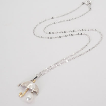 Mikimoto Umbrella Necklace made of silver, K18 gold, and pearl shown on a white background