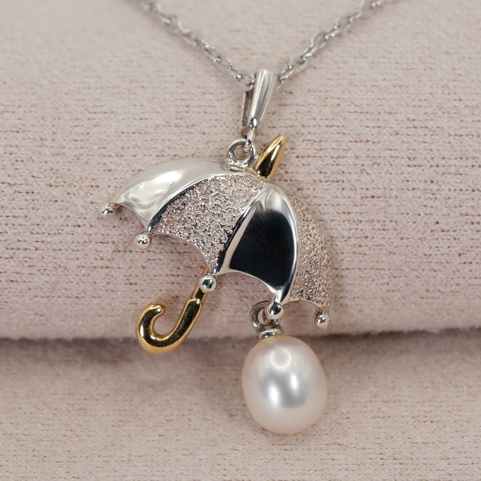 Mikimoto Umbrella Necklace made of silver, K18 gold, and pearl shown on a white background