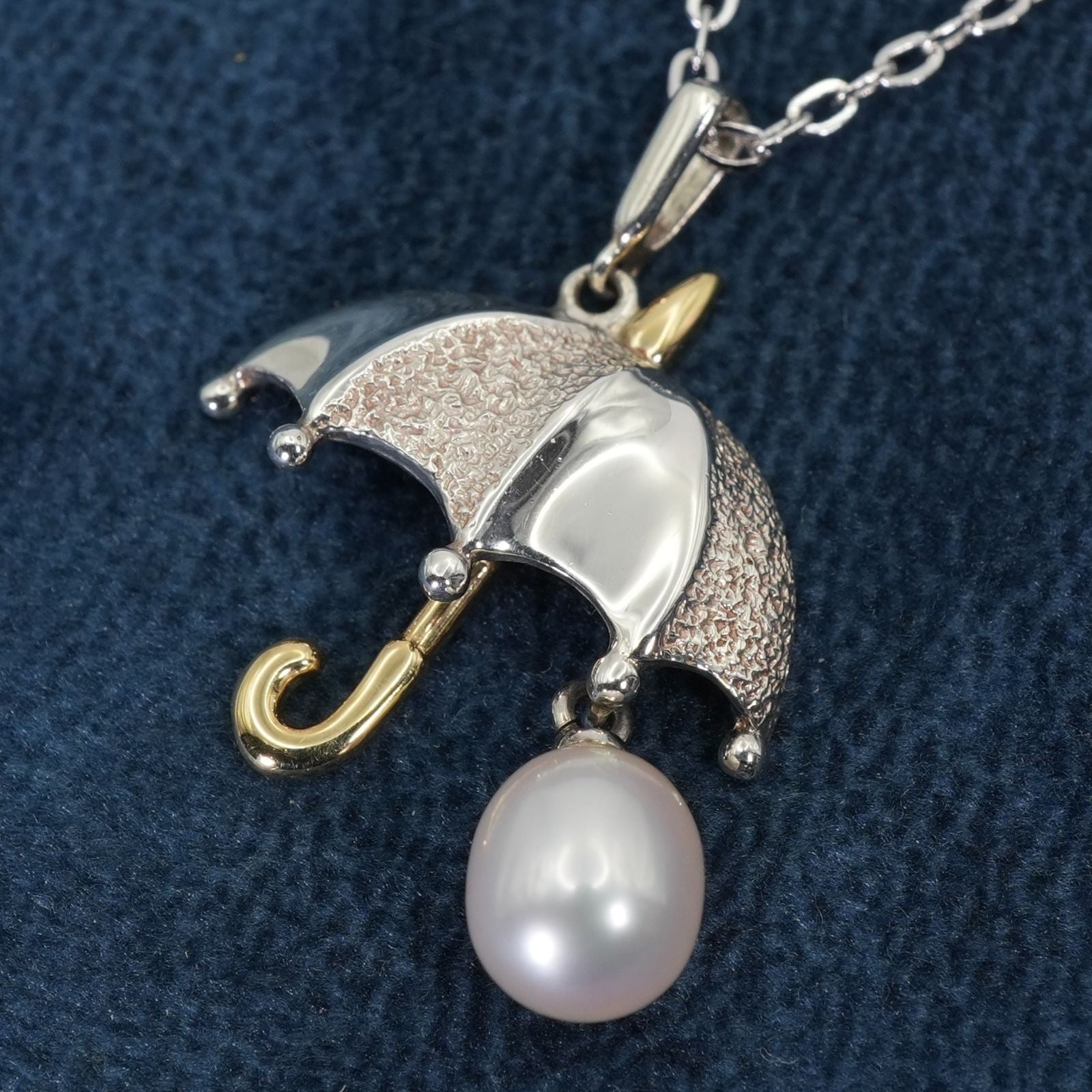 Mikimoto Umbrella Necklace made of silver, K18 gold, and pearl shown on a white background