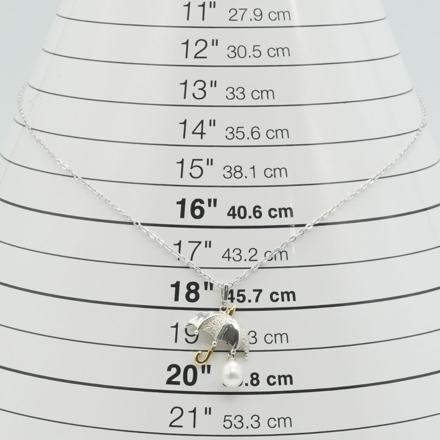 Mikimoto Umbrella Necklace made of silver, K18 gold, and pearl shown on a white background