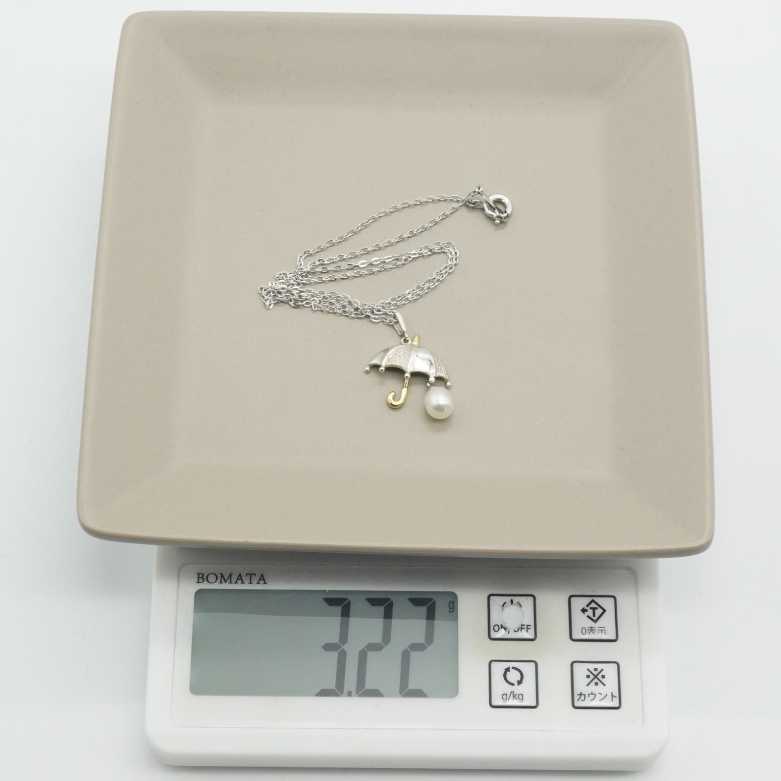 Mikimoto Umbrella Necklace made of silver, K18 gold, and pearl shown on a white background
