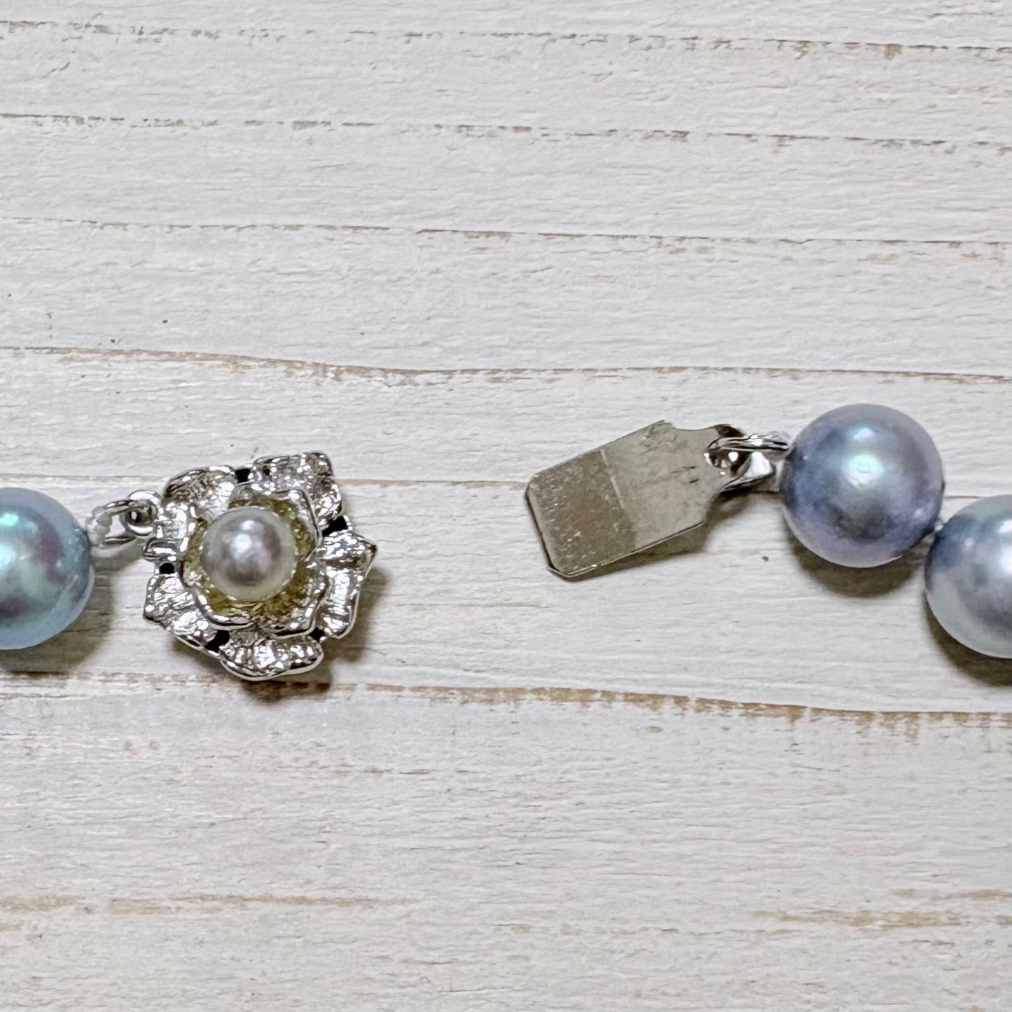 Honmei pearl necklace featuring 8mm blue gray pearls and silver engraved clasp on a white background