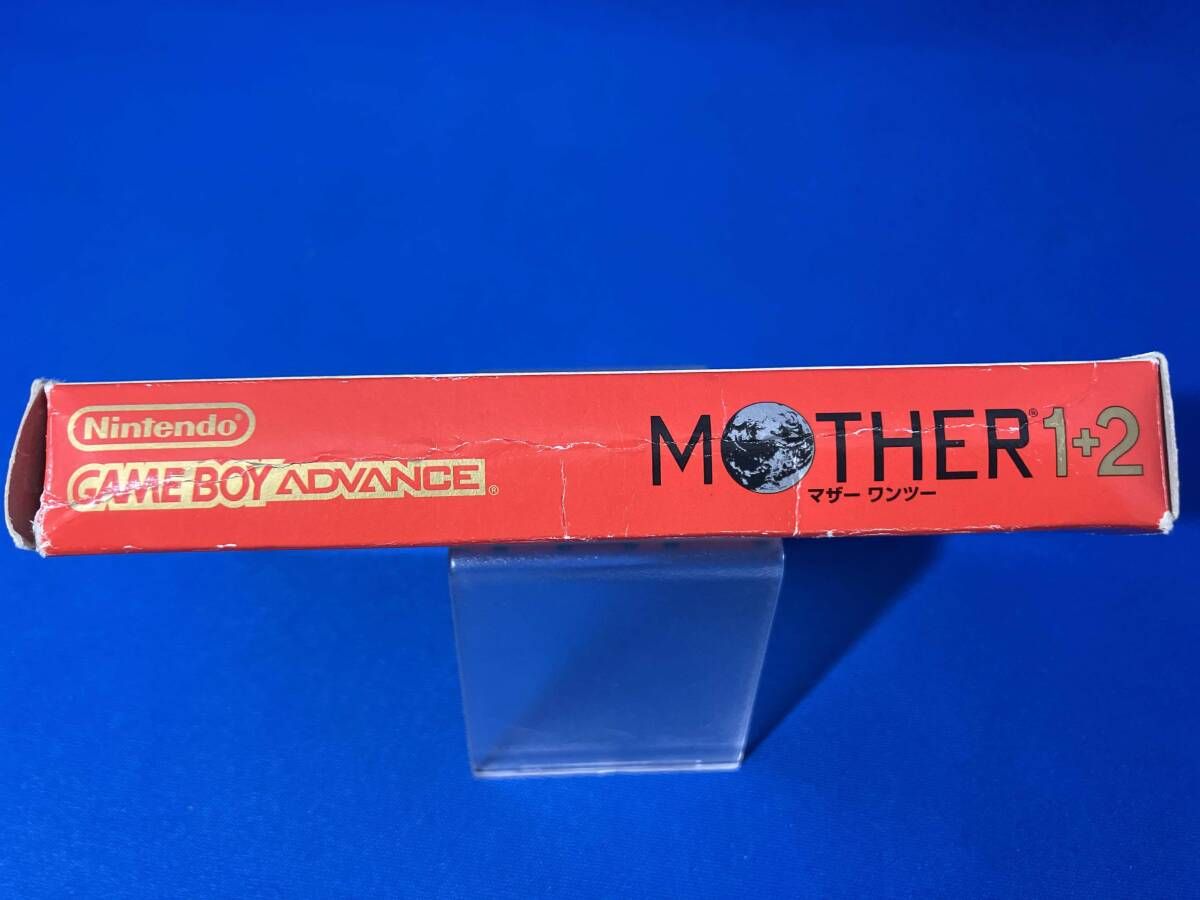 MOTHER1+2 game cartridge with damaged box and manual showing visible scratches and wear