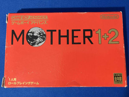 MOTHER1+2 game cartridge with damaged box and manual showing visible scratches and wear