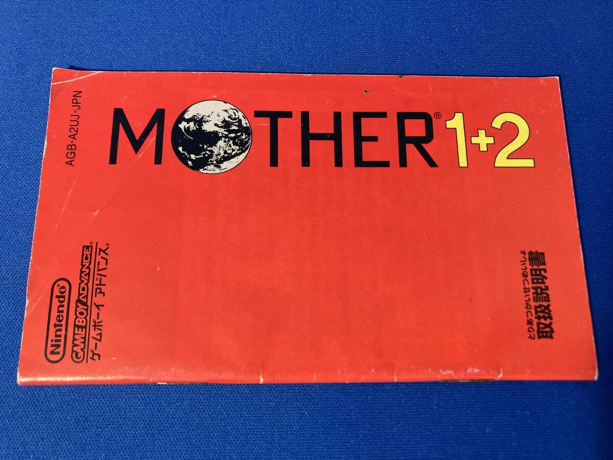 MOTHER1+2 game cartridge with damaged box and manual showing visible scratches and wear