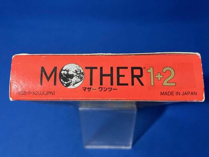 MOTHER1+2 game cartridge with damaged box and manual showing visible scratches and wear