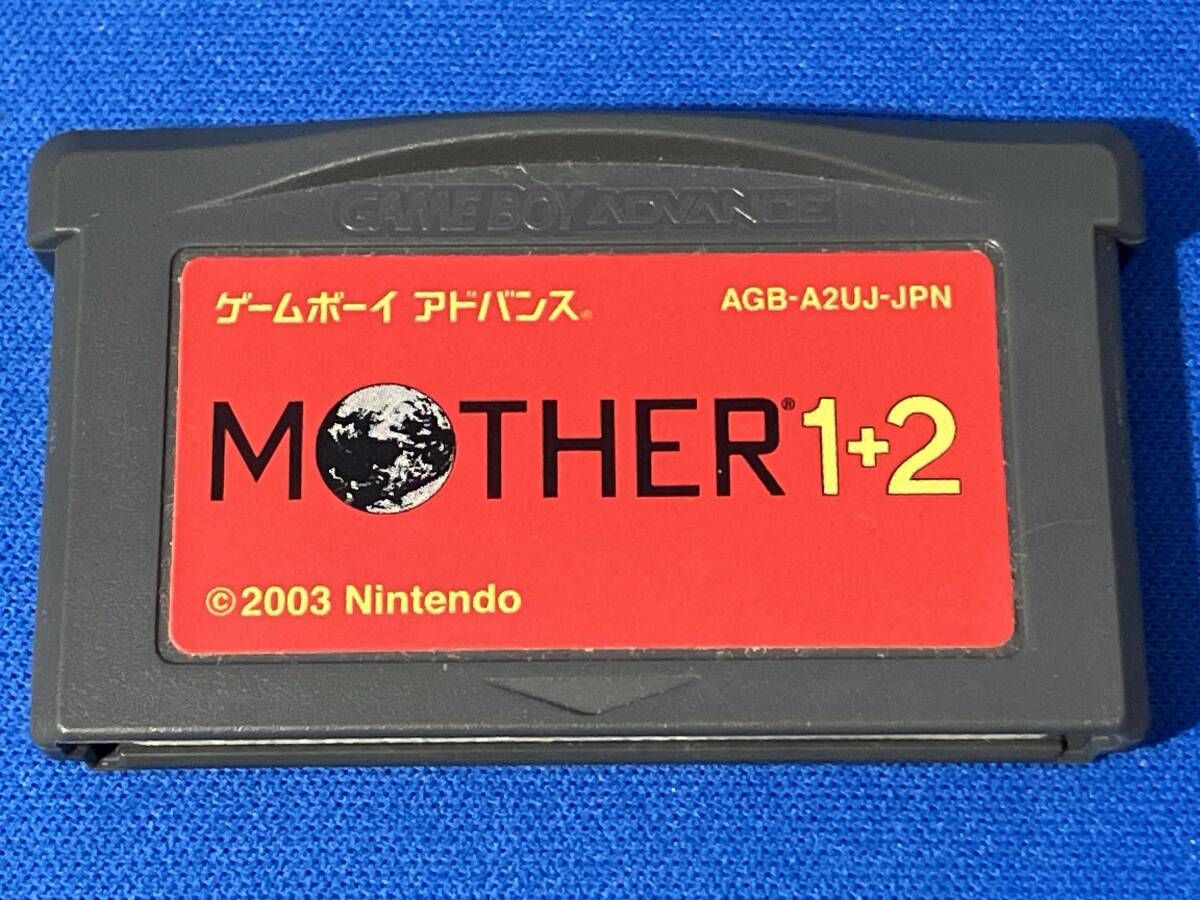 MOTHER1+2 game cartridge with damaged box and manual showing visible scratches and wear