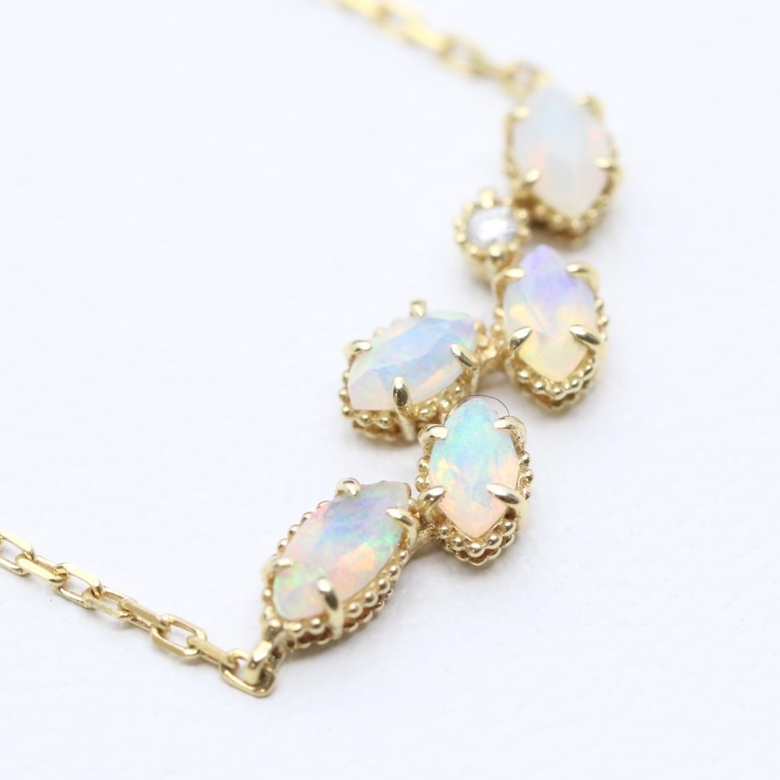 Valuable discontinued agate opal necklace with K18 and K14 gold and diamond accents on 5mm grid background